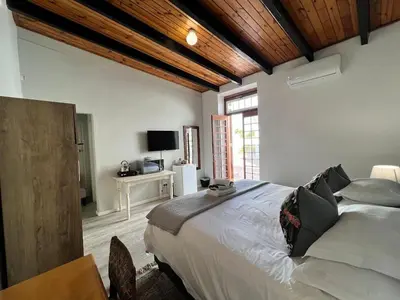 a bedroom with a large bed and a television at Avignon Guesthouse in Worcester