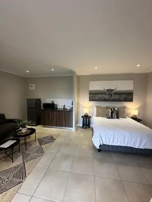 a large bedroom with a bed and a living room at Best Rest Somerset 3 in Somerset West