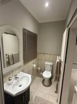 a bathroom with a white toilet and a sink at Best Rest Somerset 3 in Somerset West