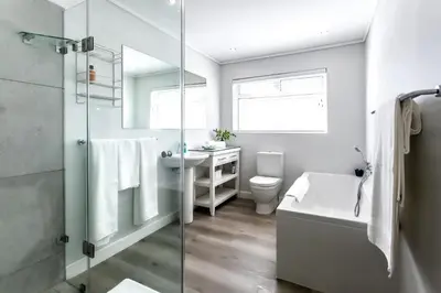 a bathroom with a shower and a toilet and a sink at The Joyful Tortoise in Hermanus