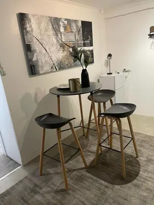 a table with two chairs and a table with a vase on it at Apartment in Gordon's Bay in Gordonʼs Bay