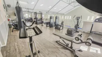 a gym with several treadmills and cardio machines at Homely 3 Bedroom apartment in Villa Italia Century City in Cape Town