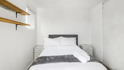 a bedroom with a bed with white sheets and pillows at Homely 3 Bedroom apartment in Villa Italia Century City in Cape Town