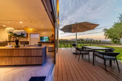 an outdoor deck with a table and an umbrella at LEO Sky Farm Cottages in Simondium