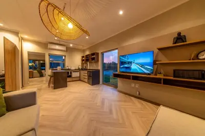 a living room with a large screen tv and a living room with at LEO Sky Farm Cottages in Simondium