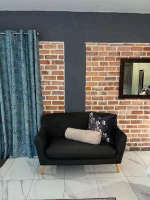 a black couch with two pillows in a living room at Southern Comfort Guest House in Bellville