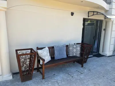 a bench sitting on a porch with pillows on it at Southern Comfort Guest House in Bellville