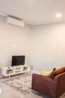 a living room with a couch and a flat screen tv at Sage And Vine Studio in Worcester