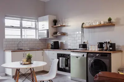 a small kitchen with a table and a dishwasher at Sage And Vine Studio in Worcester