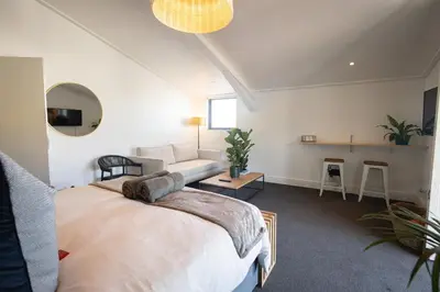 a bedroom with a bed and a couch in a room at Mountain-View Studio - Hermanus Waterfront Apartments in Hermanus