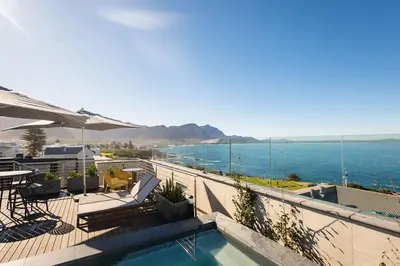 a swimming pool with a view of the ocean at Mountain-View Studio - Hermanus Waterfront Apartments in Hermanus