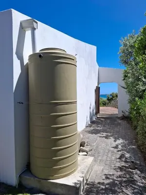 a largeige barrel sitting on the side of a building at Alibi at the Sea in Bettyʼs Bay