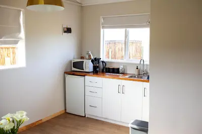 a kitchen with white cabinets and a microwave at Kleinhuisie in Hermon
