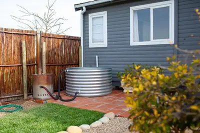 a yard with a house with a barrel next to a fence at Kleinhuisie in Hermon