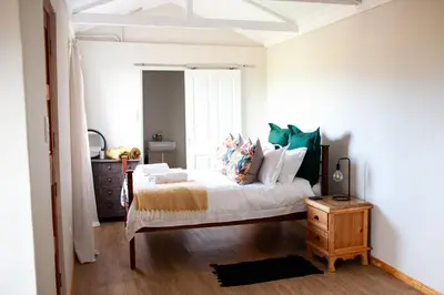 a bedroom with a bed and a dresser at Kleinhuisie in Hermon