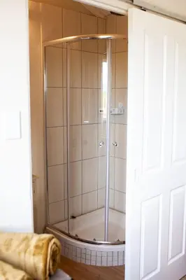 a shower with a glass door in a bathroom at Kleinhuisie in Hermon