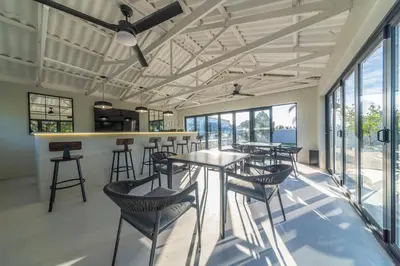a bar with tables and chairs in a room with windows at LEO Sky Guest House in Simondium