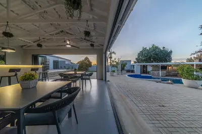 a patio with tables and chairs and a pool at LEO Sky Guest House in Simondium