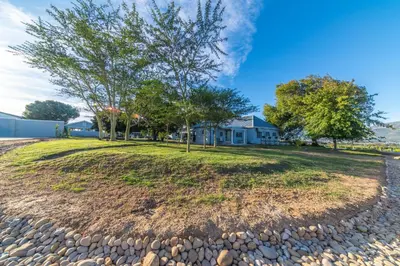 a large yard with trees and a house at LEO Sky Guest House in Simondium