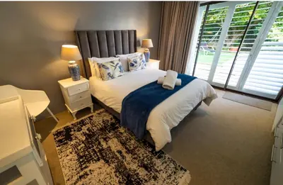 a bedroom with a large bed and a window at Close to the sea and sea path in Hermanus