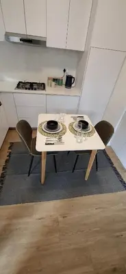 a white table and chairs in a kitchen at Blouberg Luxury Studio Apartment in Cape Town