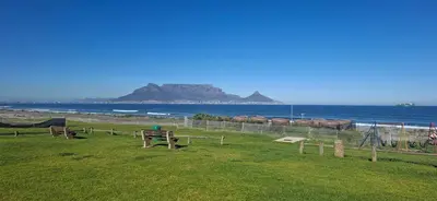 a park with a view of the beach and the ocean at Blouberg Luxury Studio Apartment in Cape Town