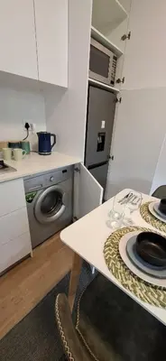 a kitchen with a table with wine glasses on it at Blouberg Luxury Studio Apartment in Cape Town
