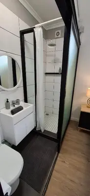 a bathroom with a toilet and a sink and a shower at Blouberg Luxury Studio Apartment in Cape Town