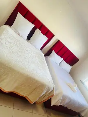 a bedroom with a large bed with a red headboard at AFRICAN HAVEN GUEST HOUSE BnB GOODWOOD in Cape Town