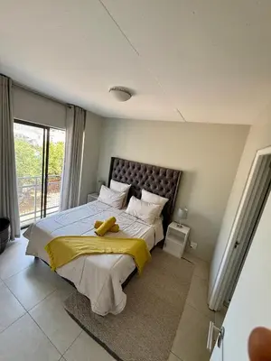 a bedroom with a large bed with a yellow blanket at Elegant 2 bedroom apartment with Mountain Views in Cape Town