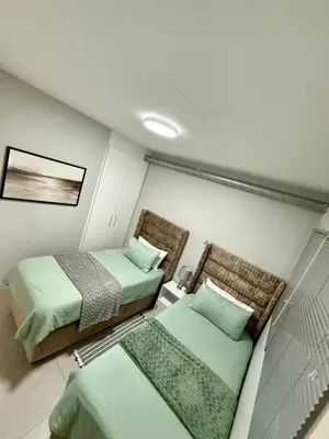a room with two beds in a room at Elegant 2 bedroom apartment with Mountain Views in Cape Town