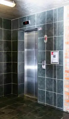 a metal elevator in a room with green tiled walls at Elegant 2 bedroom apartment with Mountain Views in Cape Town