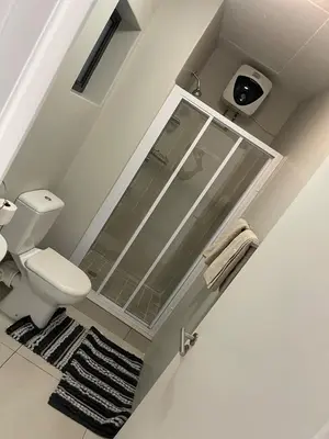 a bathroom with a toilet and a glass shower at Elegant 2 bedroom apartment with Mountain Views in Cape Town