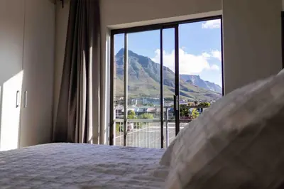 a bedroom with a bed with a view of a mountain at Elegant 2 bedroom apartment with Mountain Views in Cape Town