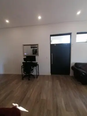 an empty room with a black door and a desk at Sandown Sun in Cape Town