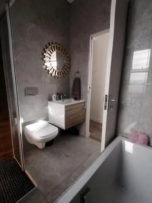a bathroom with a toilet and a sink and a tub at Sandown Sun in Cape Town