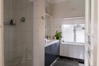 a bathroom with a shower and a sink at Wholeness Accommodation in Hermanus