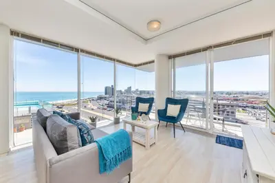 a living room with views of the ocean from windows at Horizon Bay 206 by HMH in Cape Town