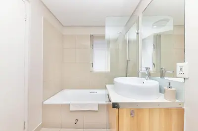 a white bathroom with a sink and a tub at Horizon Bay 206 by HMH in Cape Town