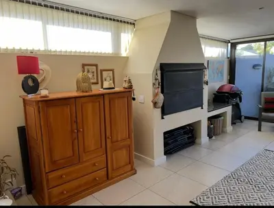 a living room with a fireplace and a wooden cabinet at Strand cosy 2 bedroom house in Strand