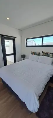 a large white bed in a room with windows at Glorious44 in Cape Town