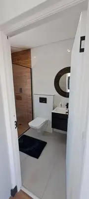 a bathroom with a toilet and a sink and a mirror at Glorious44 in Cape Town