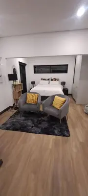 a bedroom with a bed and two couches in front thereof at Glorious44 in Cape Town