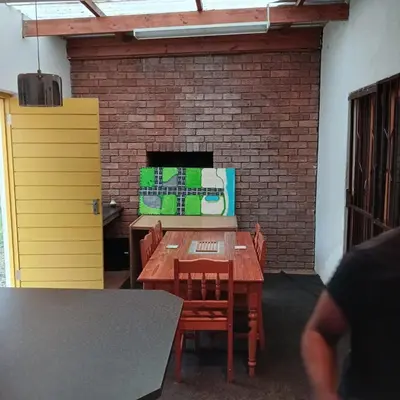 a table and chairs in a room with a brick wall at Tripple S in Bellville
