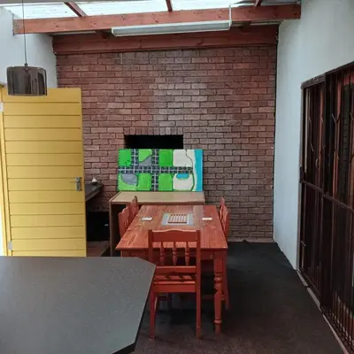 a room with a table and chairs and a brick wall at Tripple S in Bellville