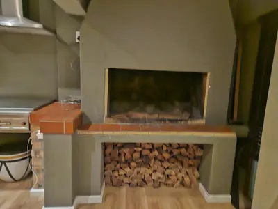 a fireplace with a pile of fire wood at Cape Golf Villa in Cape Town
