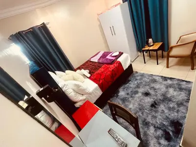 a small bedroom with a bed with a red blanket at Forest Home Accommodation in De Grendel