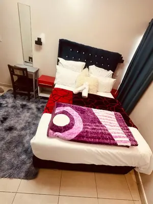 a bedroom with a bed with a purple blanket on it at Forest Home Accommodation in De Grendel