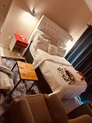 a bed in a small room with a table at Forest Home Accommodation in De Grendel