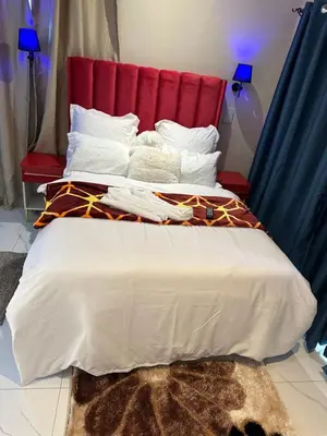 a large bed with a red headboard and white pillows at Forest Home Accommodation in De Grendel